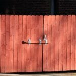 Rustykalne czerwone drewniane ogrodzenie z metalowym zamkiem
