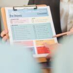 Dłonie trzymające checklistę odbioru mieszkania na klipie