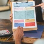 Pośrednik wyjaśnia klientom checklistę odbioru mieszkania w biurze