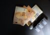 Ile kosztuje budowa domu w 2026 roku? Jak przygotować realny budżet Banknoty euro i modele domów na ciemnym tle